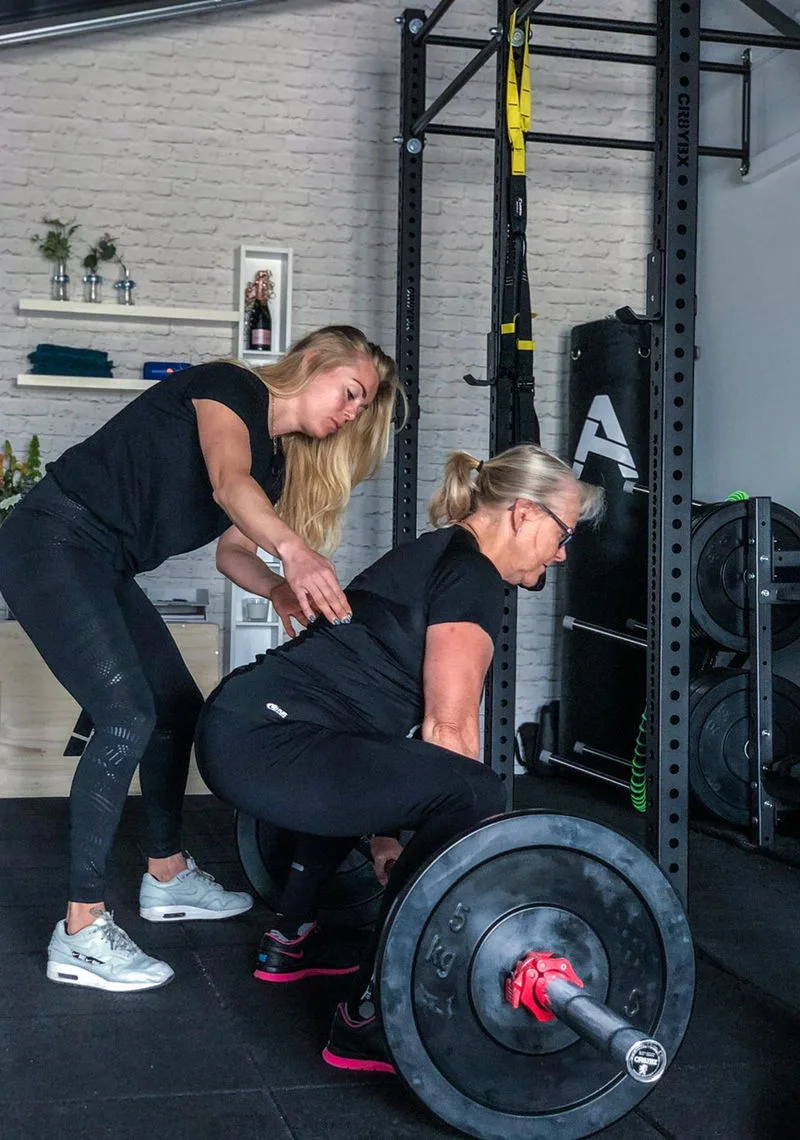 Personal trainer Annely Tempel begeleidt klant bij krachttraining studio Hoogeveen