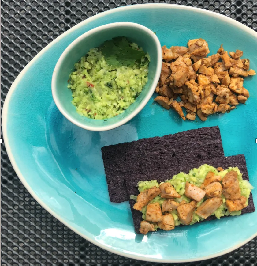 Zwarte rijstcracker met guacamole en kipfilet